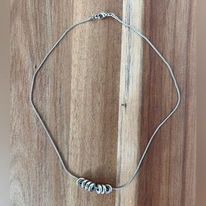 Silver tone necklace with sliding disks
